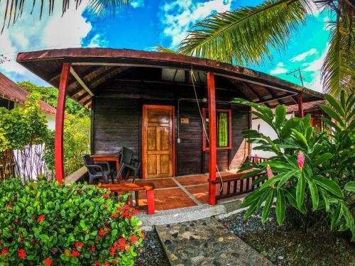 a small house with a wooden door and a porch at Tacarcuna Lodge in Capurganá