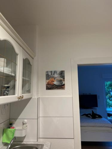 una cocina con armarios blancos y fregadero en Appartement am Teich, en Krefeld