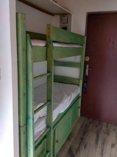 - un lit superposé vert dans un dortoir dans l'établissement location studio vacances ou weekend Pra Loup résidence La Croix Haute, à Uvernet