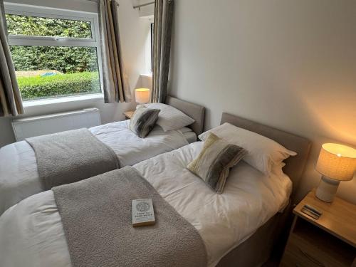 two beds in a small room with a window at Shorelands in Wadebridge