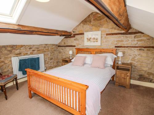 a bedroom with a wooden bed and a wooden bench at The Coach House in Ludlow