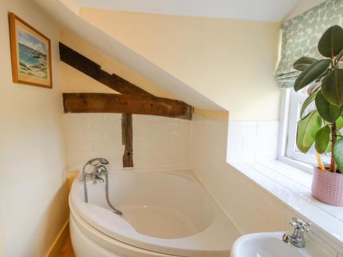 a bathroom with a bath tub and a sink at The Coach House in Ludlow