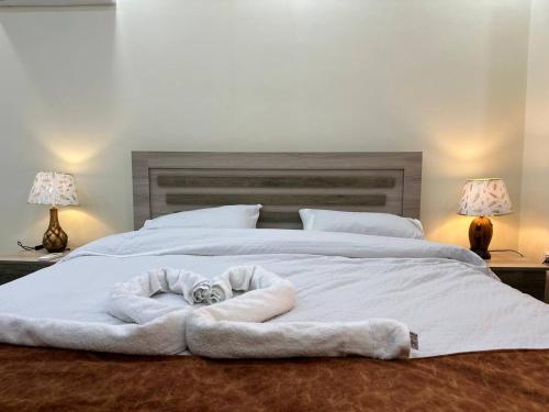 a large white bed with a white blanket on it at Dream house hotel jerash in Jerash