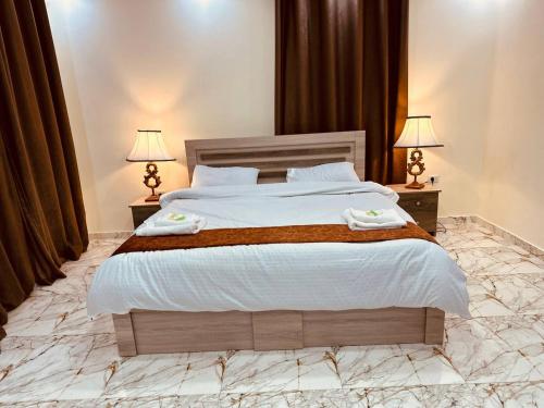 傑拉什的住宿－Dream house hotel jerash，一间卧室配有一张大床和两盏灯
