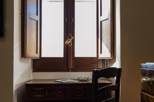 a wooden desk with a chair in front of a window at San Leonardo - ApartHotel in Laterza