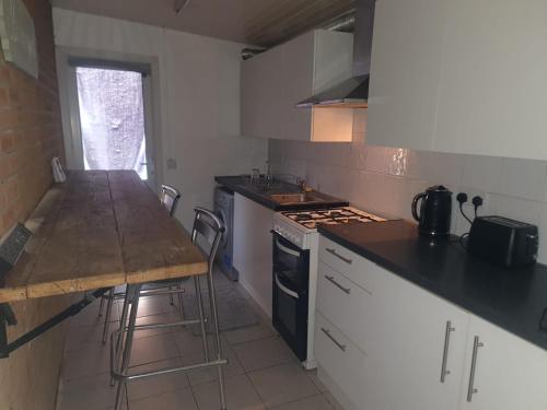 cocina con mesa y fogones horno superior en One Bedroom Apartment with Garden, en Londres