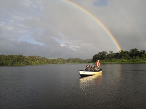 a group of people in a boat with a rainbow at Tortuguero Adventures Beach House in Tortuguero