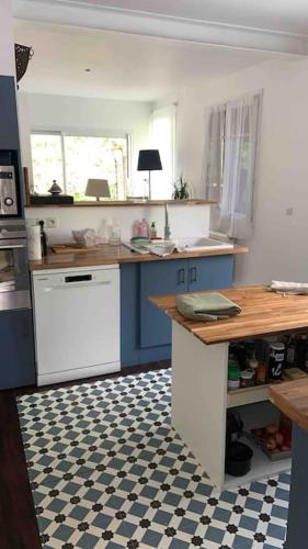 une cuisine avec des appareils électroménagers bleus et blancs et un sol à carreaux dans l'établissement Maison basque avec jardin, à Bidart