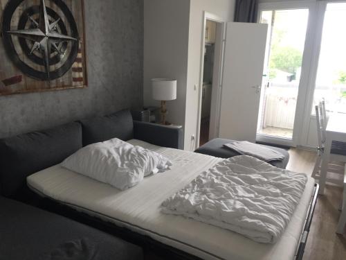 uma cama com um edredão branco num quarto em FeWo Nordseestraße em Büsum