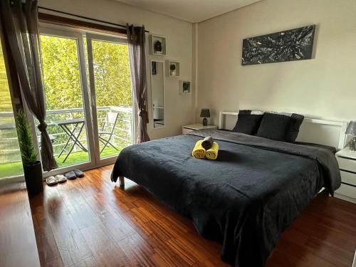 1 dormitorio con cama grande y ventana grande en Private Bedroom with Balcony & Private Bathroom in Modern Shared Apartment - King & Queen size bed, en Vila Nova de Gaia