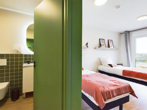 a room with two beds and a bathroom at Hife Toulouse Sud Labège in Labège