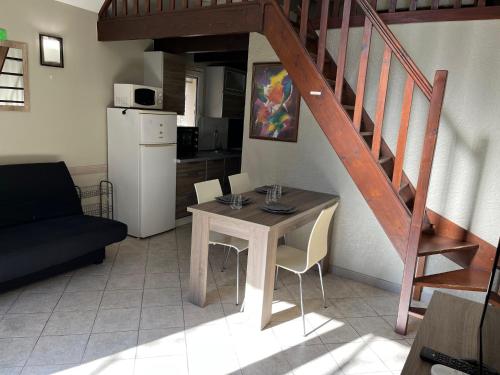 uma sala de estar com uma mesa e uma escada em RESID'ARTEL em Fos-sur-Mer