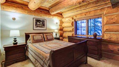 ein Schlafzimmer mit einem Bett und einem Fenster in einem Blockhaus in der Unterkunft Paradise Meadow Lodge in Breckenridge