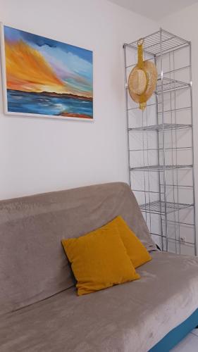 - un lit avec un oreiller jaune dans l'établissement Confortable studio bord de mer, à Canet