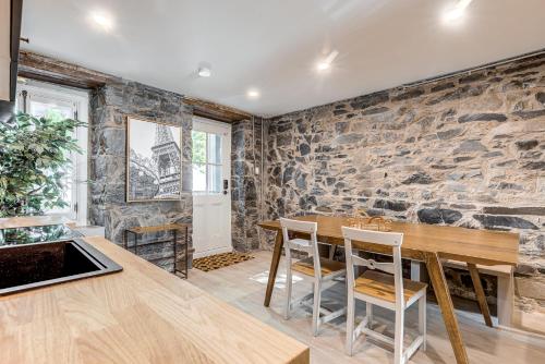 a dining room with a stone wall at Beautiful Vieux 2 Bedroom Apt in Quebec City