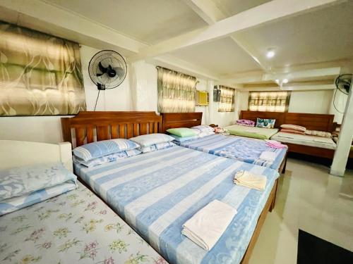 two beds in a room with two beds sidx sidx sidx at King Henry's Transient House in Bantay