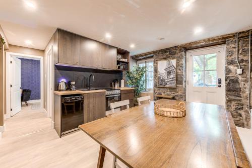 a kitchen with a wooden table and a dining room at North House - Beautiful Vieux 2 Bedroom Apt in Quebec City