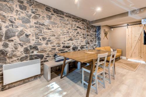 a dining room with a stone wall at Beautiful Vieux 2 Bedroom Apt in Quebec City