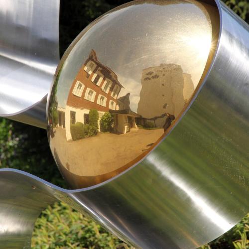 a reflection of a building in the side view mirror of a spoon at Guggital Hotel Restaurant in Zug