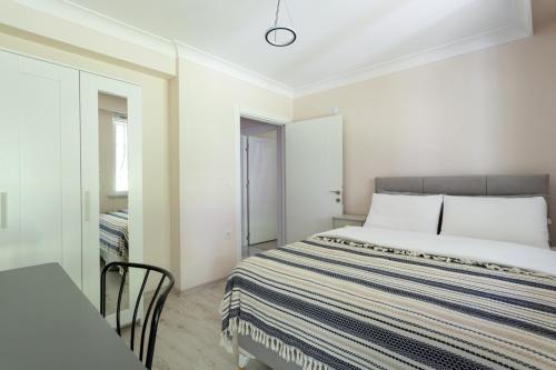 a white bedroom with a bed and a chair at One and Only Brandnew Full Apartment in Istanbul