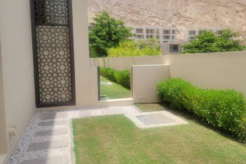 muscat bay nameer villa في مسقط: غرفة مطلة على ساحة مع عشب