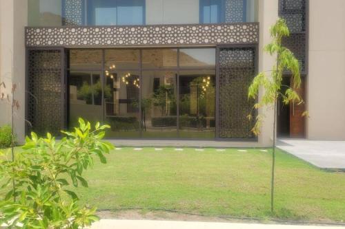 muscat bay nameer villa في مسقط: منزل أمامه ساحة نخلة