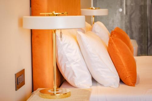 a lamp sitting on top of a bed with pillows at Santa Lucia Boutique Hotel in Santa Luċija