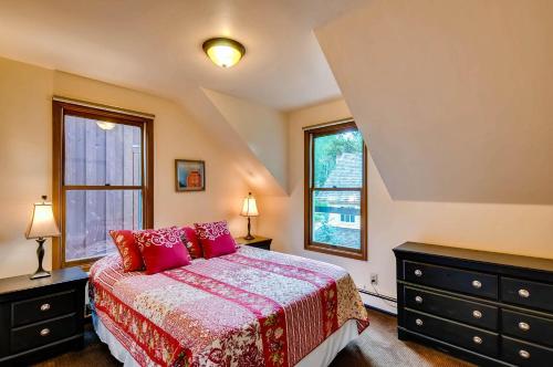 a bedroom with a bed and two windows at Ravens Call Chalet in Breckenridge