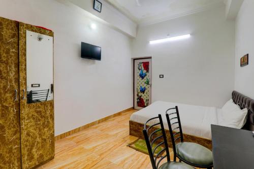 a room with a bed and a table and a door at OYO Xpress Home in Lucknow