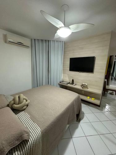 a bedroom with a bed and a flat screen tv at Apartamento Areia Preta Guarapari in Guarapari