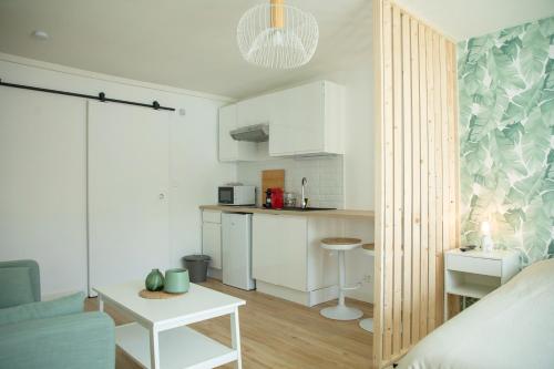 a room with a kitchen and a living room at Le Jade - Appart'Escale in Saint-Nazaire