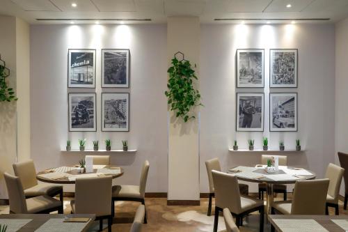 a restaurant with tables and chairs and pictures on the wall at Mercure Warszawa Grand in Warsaw