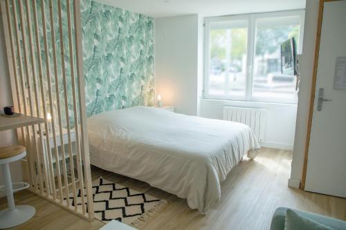 ein Schlafzimmer mit einem weißen Bett und einem Fenster in der Unterkunft Le Jade - Appart'Escale in Saint-Nazaire
