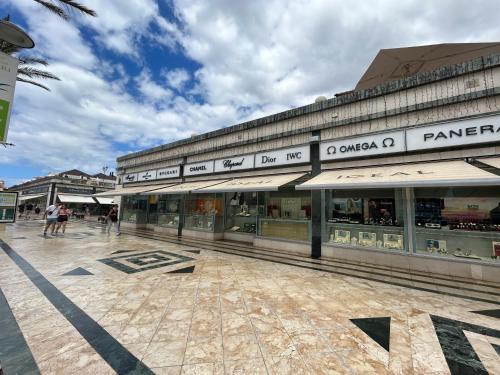 a building with people walking in front of it at 5 min walk to Gold Mile and 7min to best Las Americas Beach WiFi in Arona