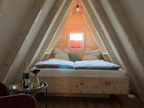 a bed in the middle of a attic with a window at Hütte 19 in Freyung