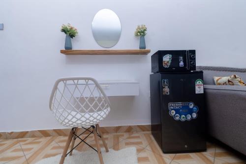 une chaise dans un salon à côté d'un réfrigérateur dans l'établissement Kilifornia Comfy Studio, à Kilifi