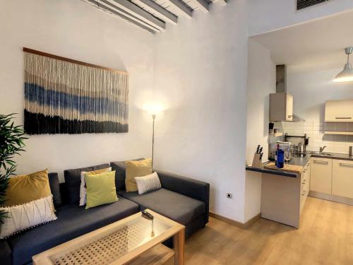 a living room with a couch and a kitchen at Apartamento centro de malaga in Málaga