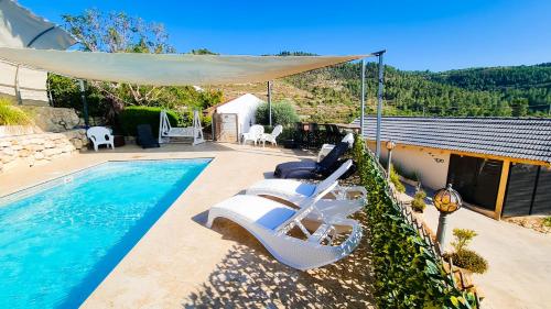 a swimming pool with lounge chairs next to a house at עיינות ספיר - Einot Sapir in Sappir