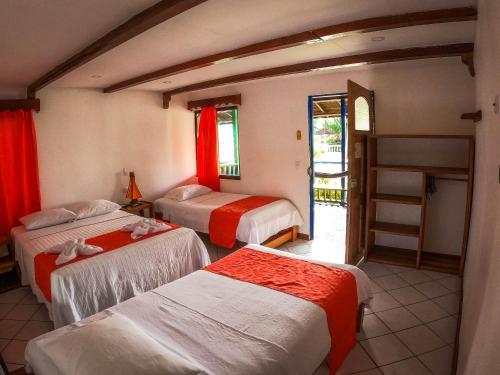 a hotel room with three beds and a staircase at Tacarcuna Lodge in Capurganá