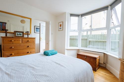 sypialnia z łóżkiem, komodą i oknami w obiekcie Unique private apartment w/ Easy access to Central London w Londynie