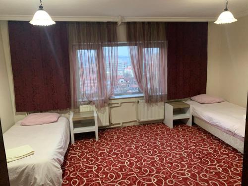 a hotel room with two beds and a window at Altunlar apart 1 in Altındağ