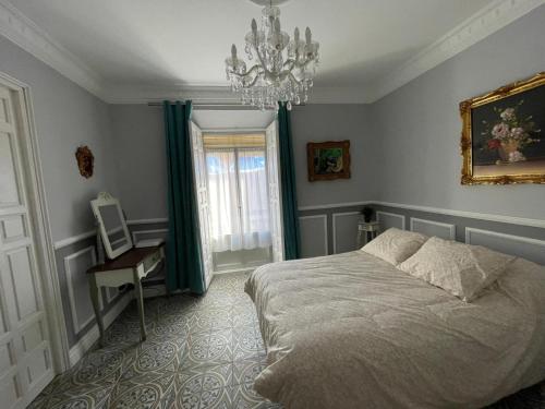 a bedroom with a bed and a chandelier at Apartamento Trasiego in Valdepeñas