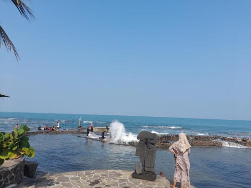 a woman standing in the water at the beach at Keraton Krakatoa in Banten