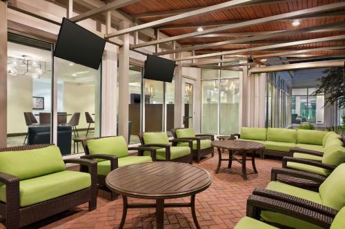 a waiting room with green chairs and tables at Hilton Garden Inn Houston Energy Corridor in Houston