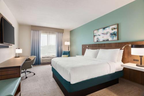 um quarto de hotel com uma cama grande e uma secretária em Hilton Garden Inn Houston Energy Corridor em Houston