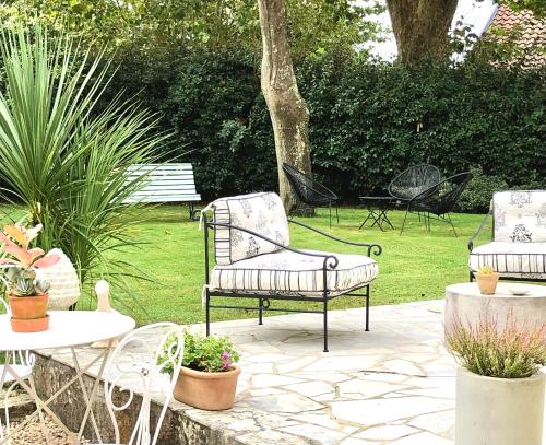 a patio with two chairs and a table and chairs at LA PARENTHÈSE in Saubrigues