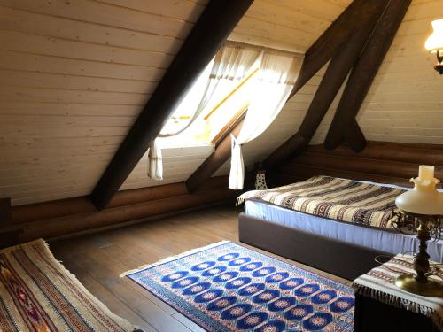 Habitación en el ático con 2 camas y alfombra en Гута Вікенд, en Guta