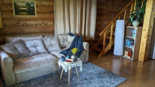 salon z kanapą i stołem w obiekcie Viesu māja Kolnā pie Adamovas ezera. 