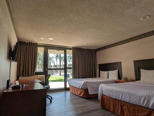 una camera d'albergo con due letti e una finestra di Valley Inn a Mission Hills