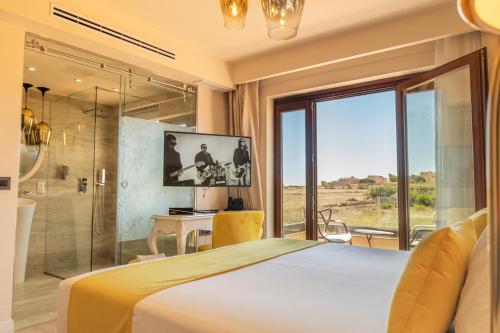 a bedroom with a large bed and a glass shower at Santa Lucia Boutique Hotel in Santa Luċija
